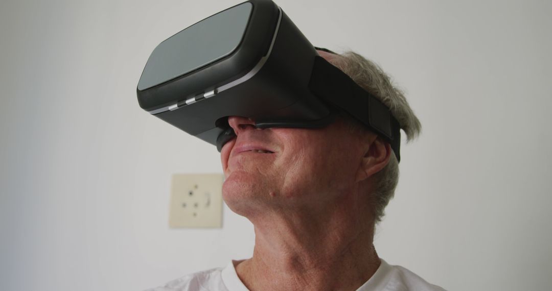 Senior Man Using Virtual Reality Headset for Entertainment