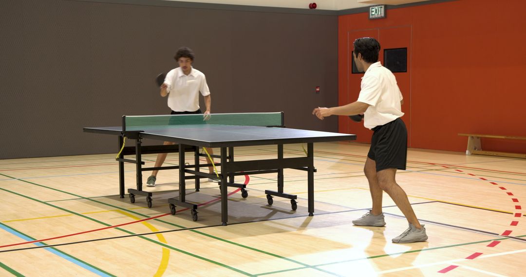Competitive Game of Table Tennis in Indoor Gymnasium
