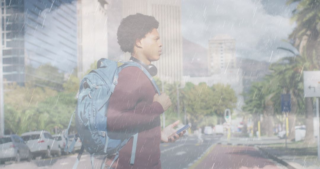 Determined Young Man Walking Through the Rain with Backpack