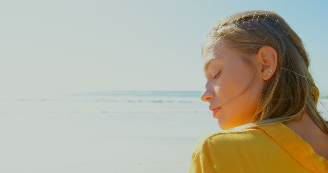 Young Woman Relaxing on Sunny Beach - Free Images, Stock Photos and Pictures on Pikwizard.com