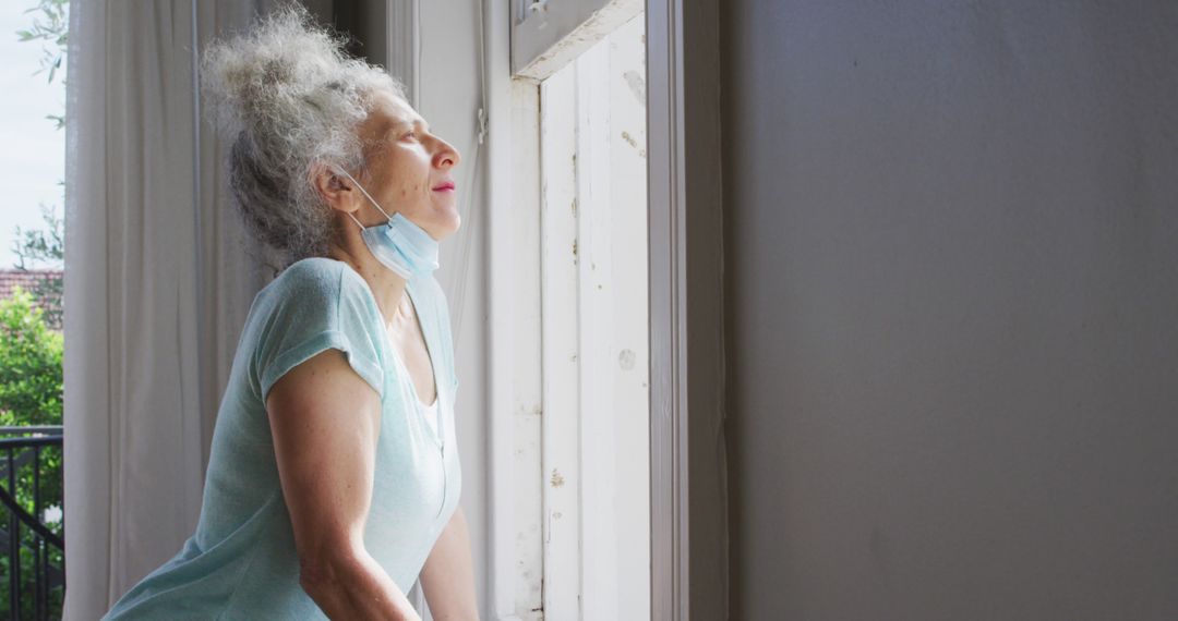 Elderly Woman with Gray Hair Enjoying Sunshine by Window at Home - Free Images, Stock Photos and Pictures on Pikwizard.com