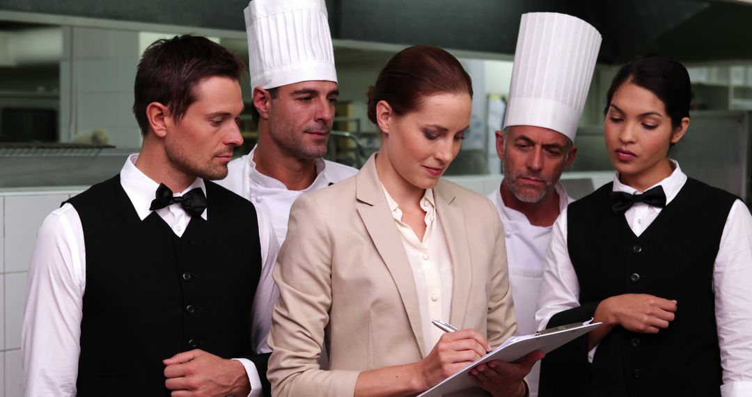 Restaurant Manager Reviewing Checklist with Staff in Kitchen - Free Images, Stock Photos and Pictures on Pikwizard.com