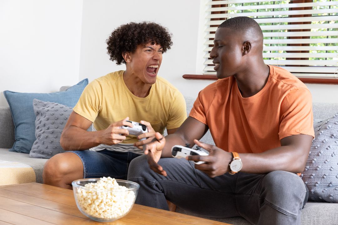 Diverse Friends Gaming and Relaxing with Popcorn at Home