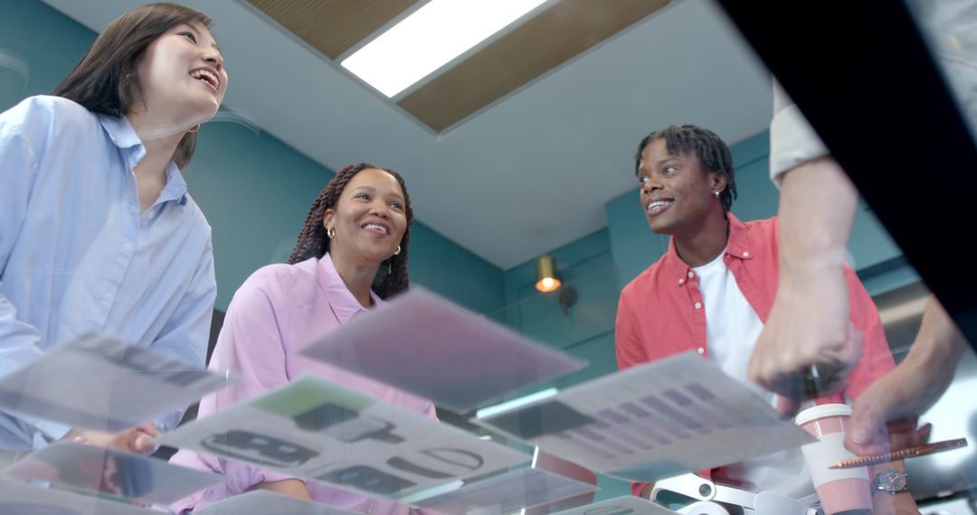 Diverse Colleagues Collaborating Energetically Around Office Table
