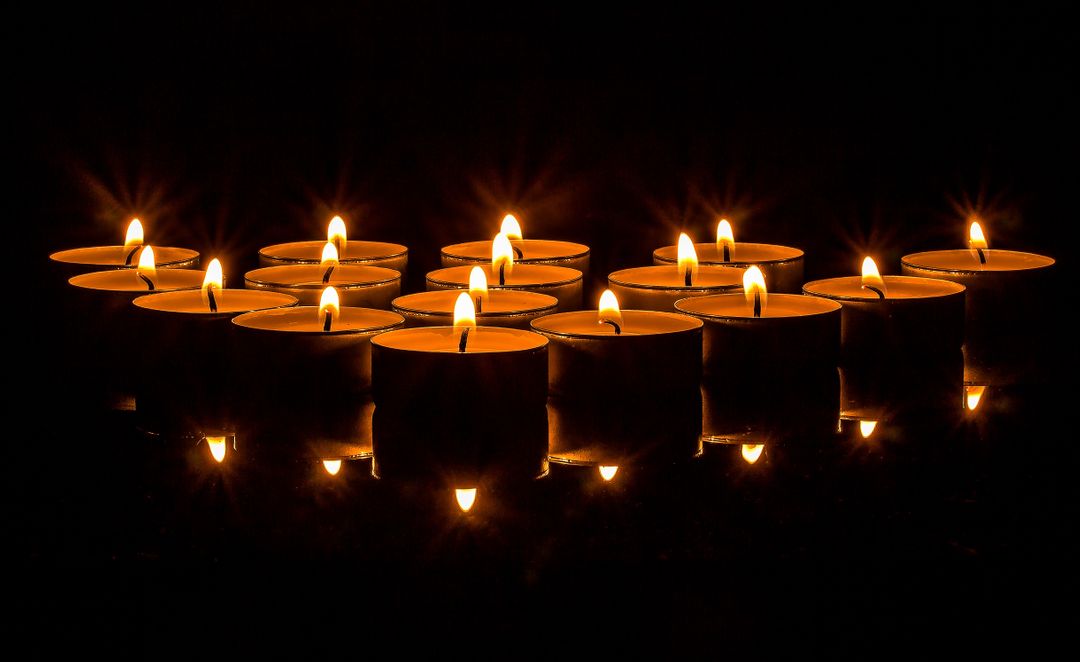 Row of lit candles glowing in the dark - Free Images, Stock Photos and Pictures on Pikwizard.com