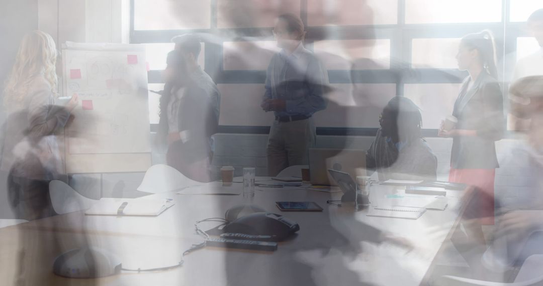 Blurred business team collaborating and brainstorming around conference table in office
