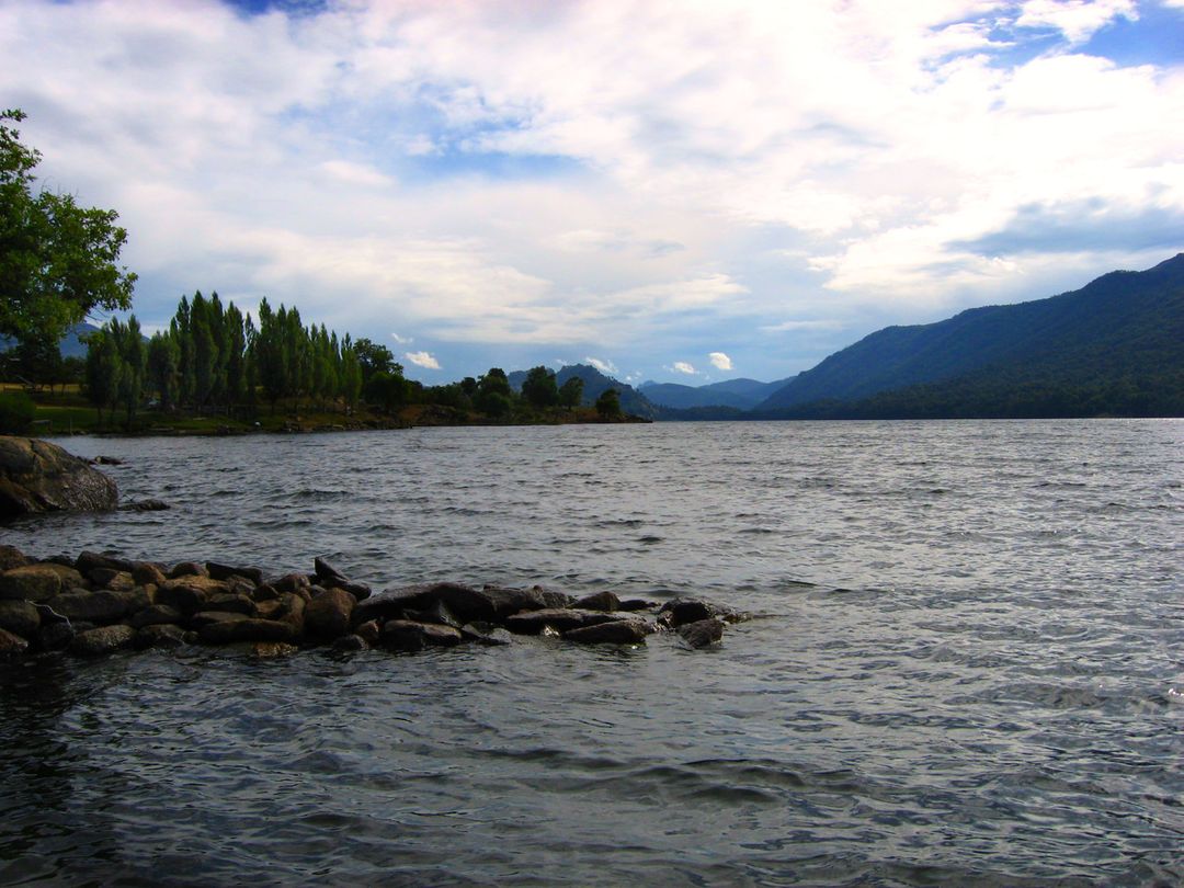 Calm Mountain Lake with Clear Skies and Lush Green Trees - Free Images, Stock Photos and Pictures on Pikwizard.com