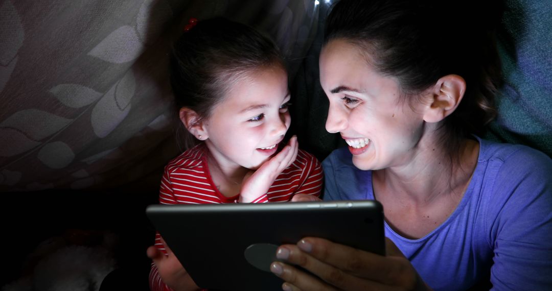 Mother and Daughter Watching Tablet Together Under Blanket Fort - Free Images, Stock Photos and Pictures on Pikwizard.com