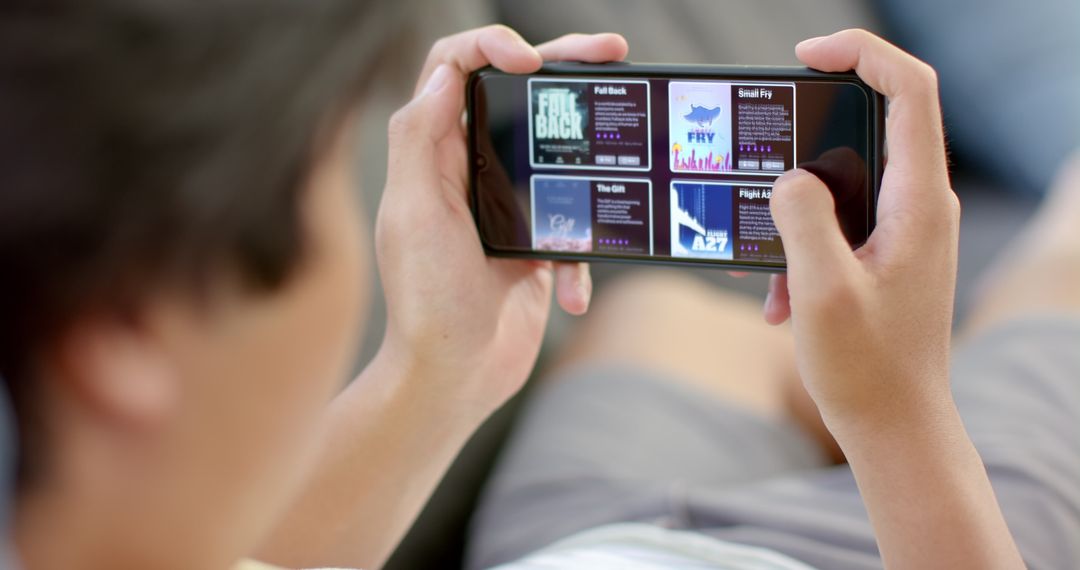 Young College Student Browsing Streaming Library on Smartphone