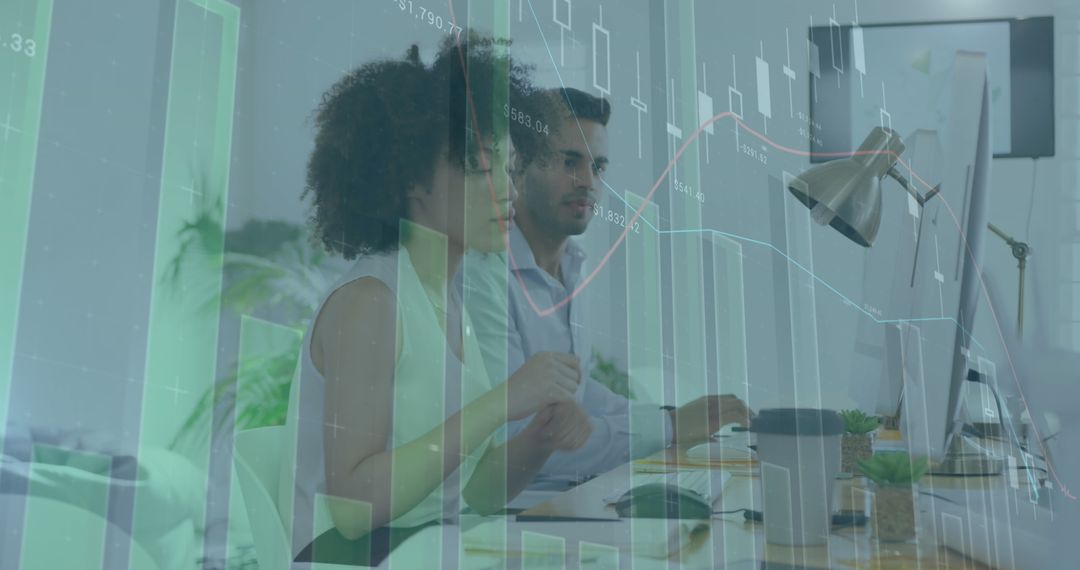 Diverse Coworkers Analyzing Data on Computers in Modern Office
