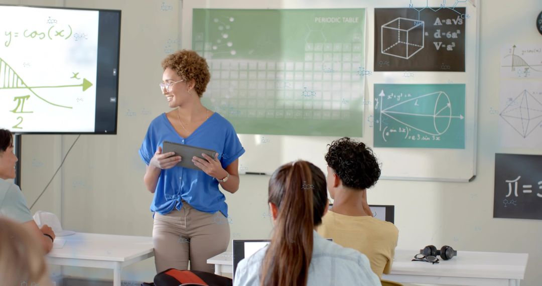 Female Teacher Using Tablet Leading Interactive Math Lesson with Student Laptops