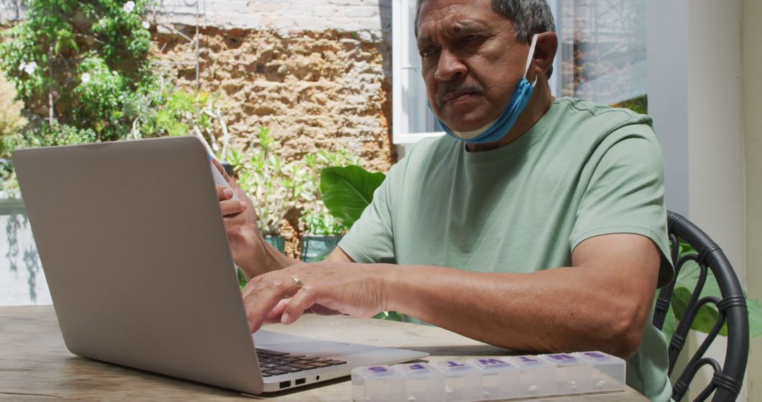 Senior Man Wearing Mask Browsing Laptop at Home - Free Images, Stock Photos and Pictures on Pikwizard.com