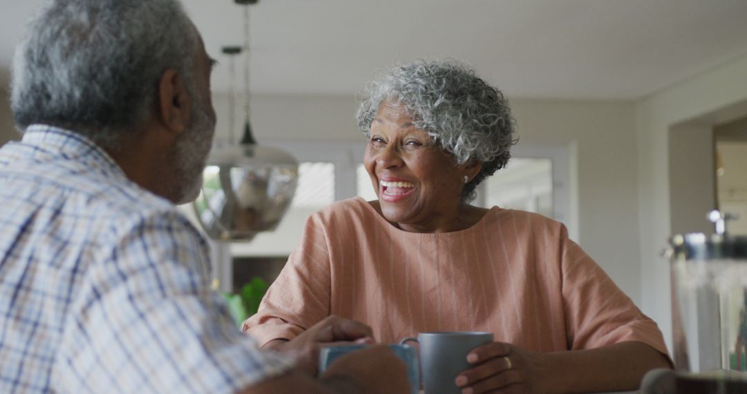 Image of happy african american senior woman with coffee talking to her male partner - Free Images, Stock Photos and Pictures on Pikwizard.com