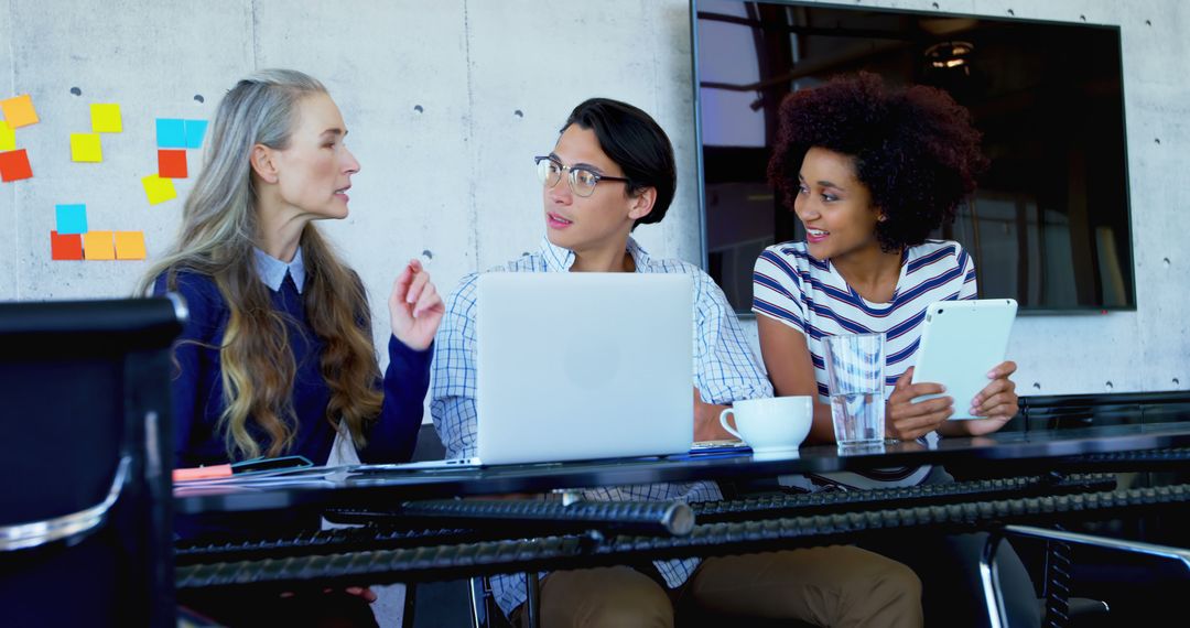 Diverse Colleagues Discussing in Modern Office with Tech Devices