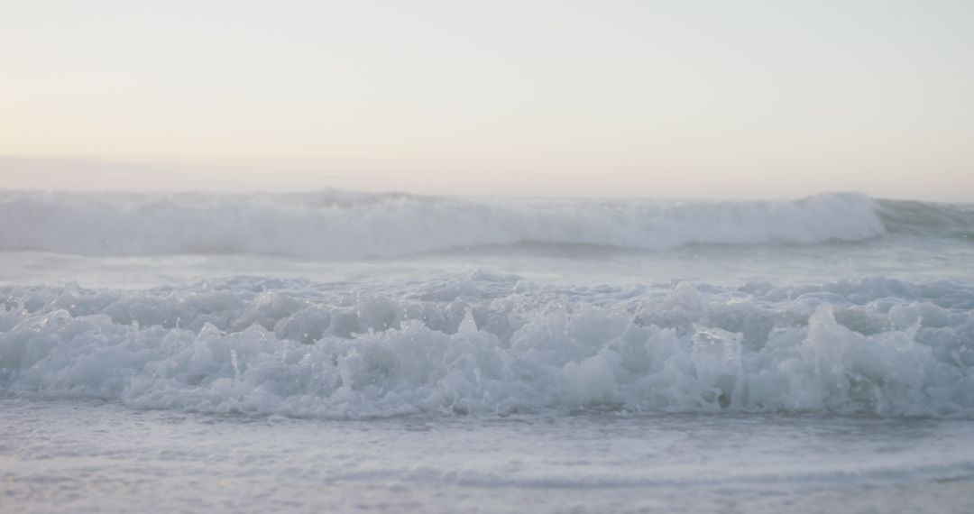 Gentle Waves Rolling Onto Tranquil Beach in Soft Daylight
