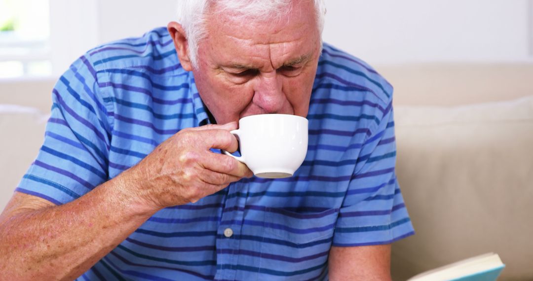 Senior Man Drinking Coffee While Reading Book at Home - Free Images, Stock Photos and Pictures on Pikwizard.com