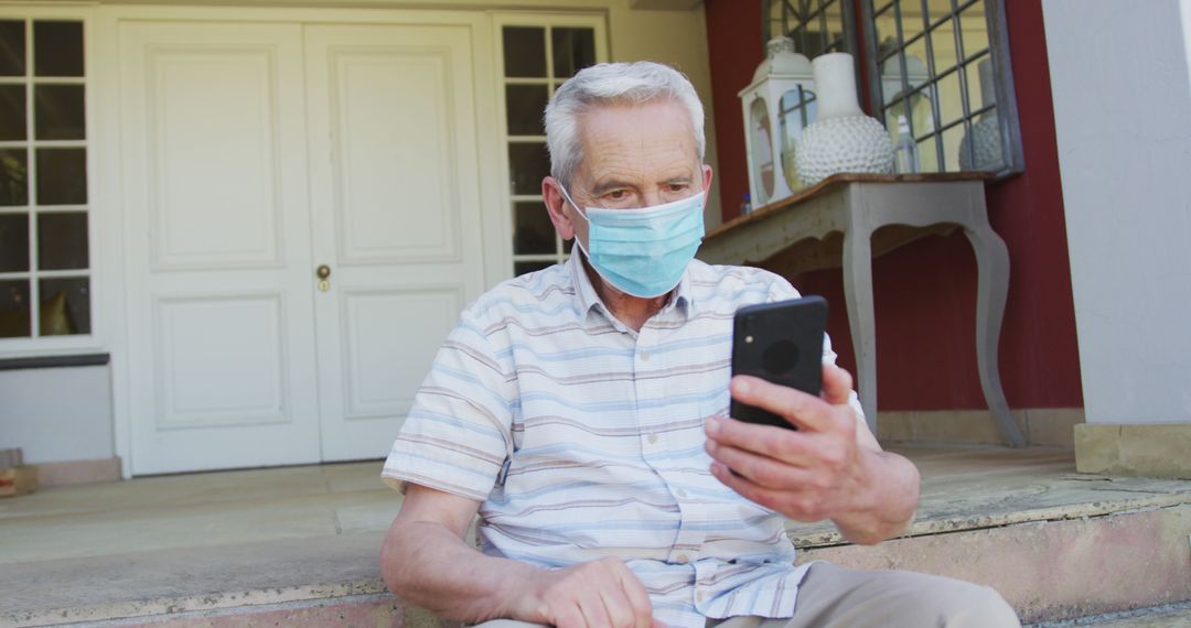 Senior Man Using Smartphone with Face Mask on Home Porch - Free Images, Stock Photos and Pictures on Pikwizard.com