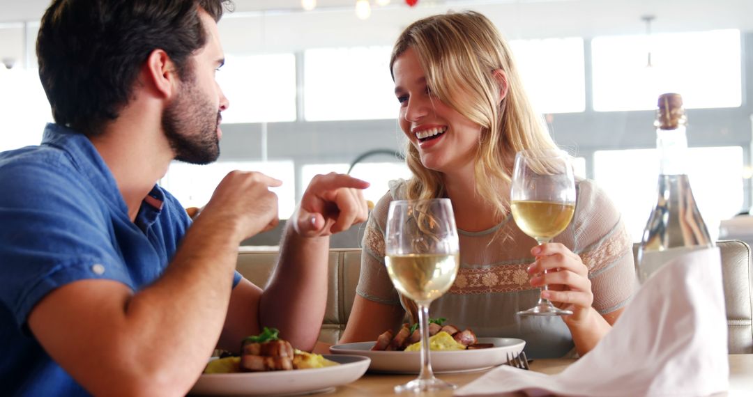 Young Couple Enjoying Wine and Conversation in Restaurant