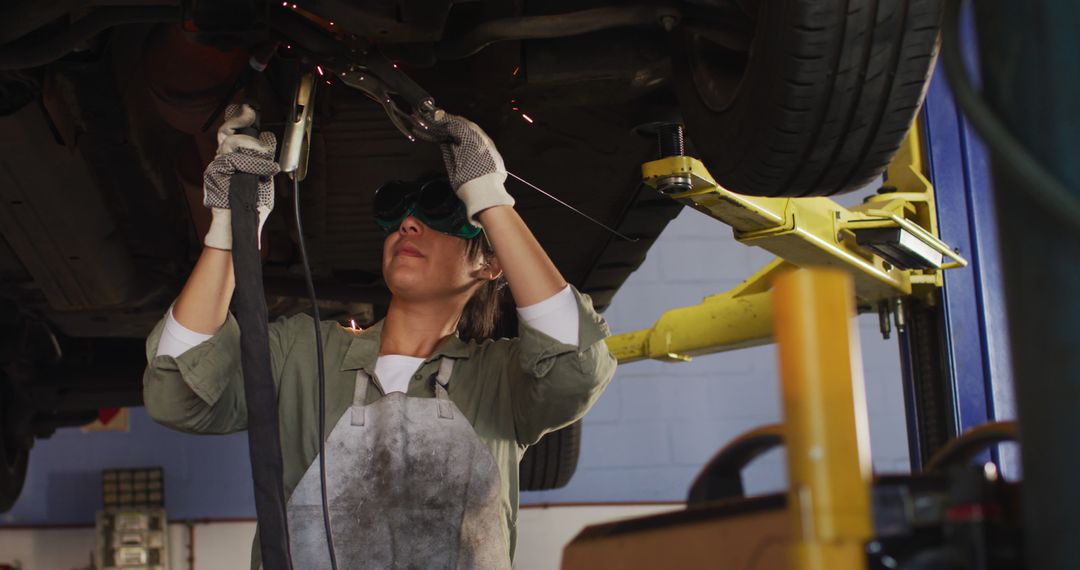 Female Mechanic Welding Under a Car on a Lift at Auto Repair Shop - Free Images, Stock Photos and Pictures on Pikwizard.com