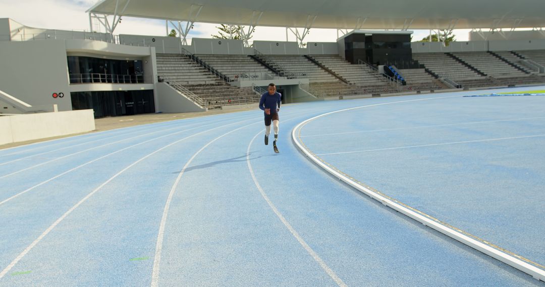 Athlete Running on Blue Track in Empty Stadium - Free Images, Stock Photos and Pictures on Pikwizard.com