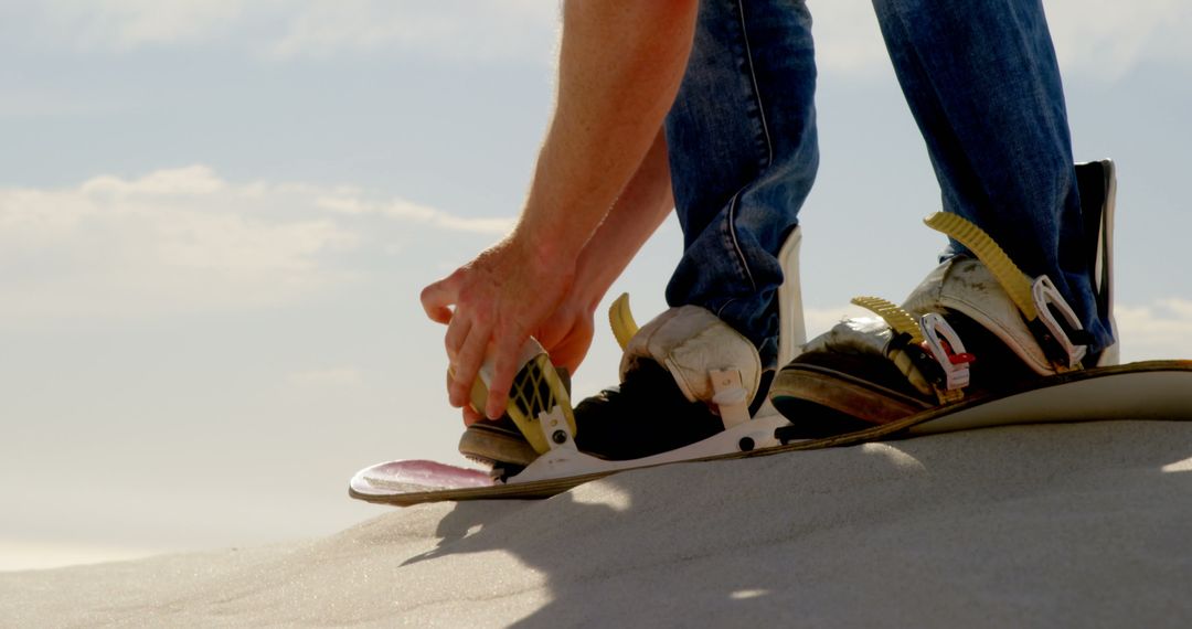 Close-up of Person Strapping Sandboard on Desert Dune - Free Images, Stock Photos and Pictures on Pikwizard.com