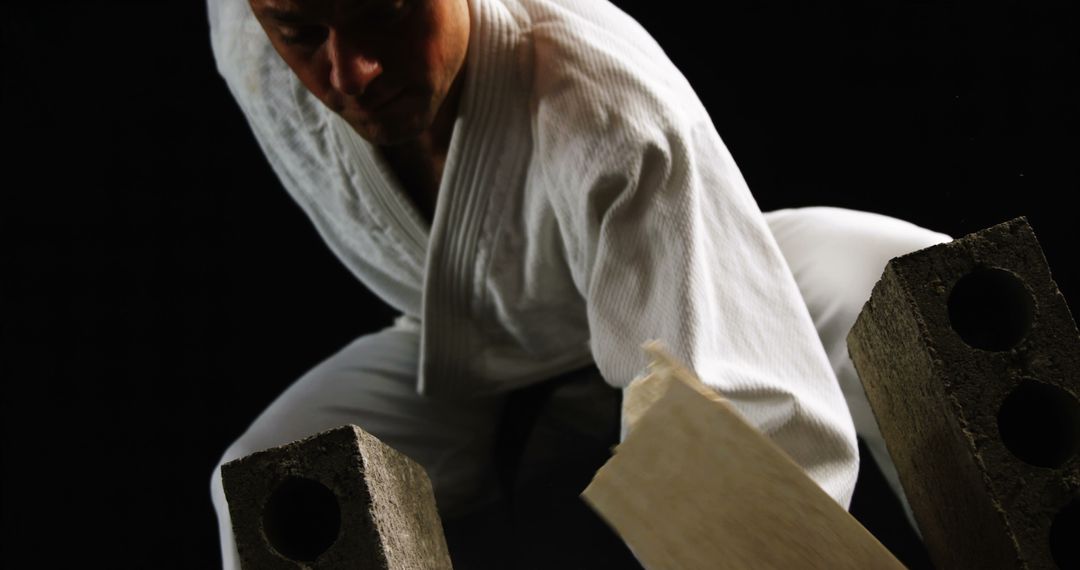 Martial Artist Breaking Wooden Plank Focused on Strength - Free Images, Stock Photos and Pictures on Pikwizard.com