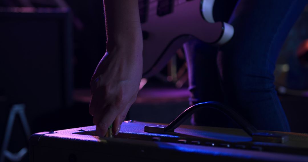 Musician Adjusting Amplifier During Live Performance - Free Images, Stock Photos and Pictures on Pikwizard.com