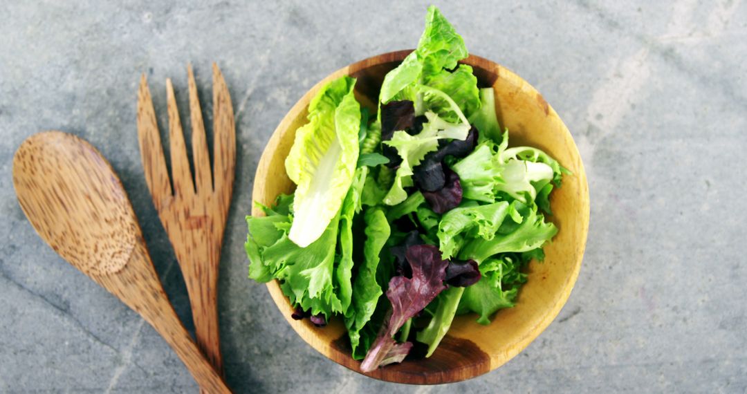 Fresh Mixed Green Salad in Wooden Bowl with Utensils - Free Images, Stock Photos and Pictures on Pikwizard.com