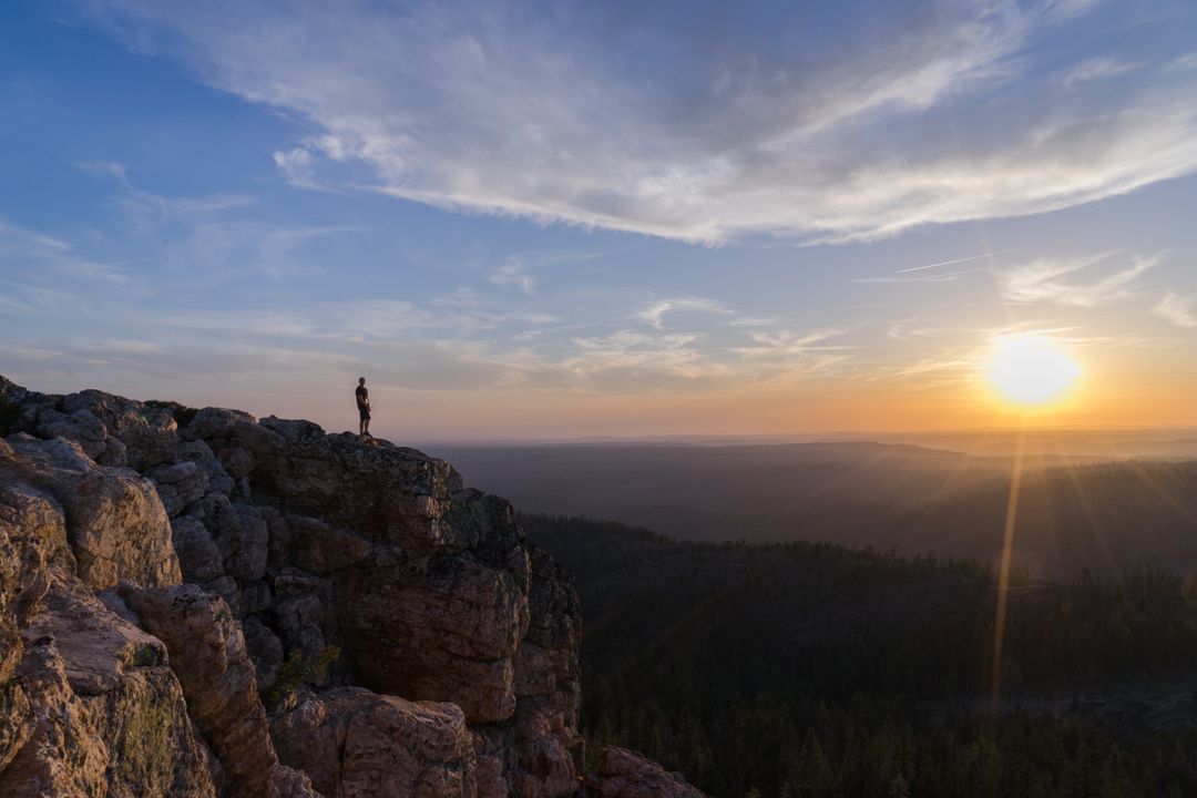 Hiker Standing on Rocky Cliff During Sunset - Free Images, Stock Photos and Pictures on Pikwizard.com