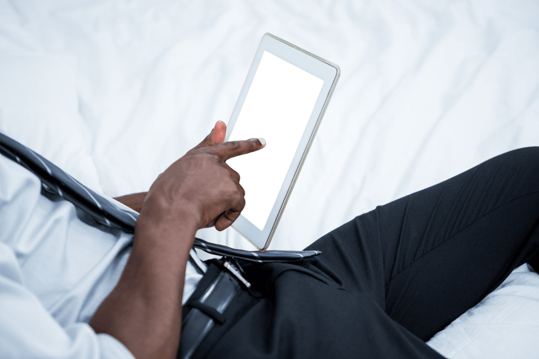 Businessman Relaxing on Bed Using Client-Focused Transparent Tablet