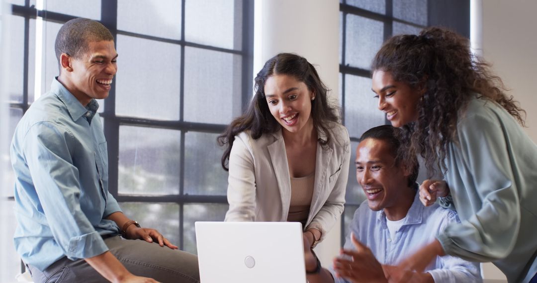 Diverse Team Celebrating Success During Laptop Meeting