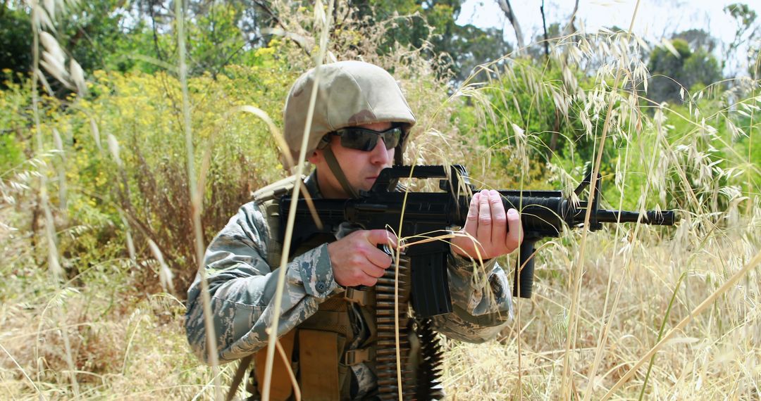 Soldier in Camouflage Aiming Rifle in Tall Grass