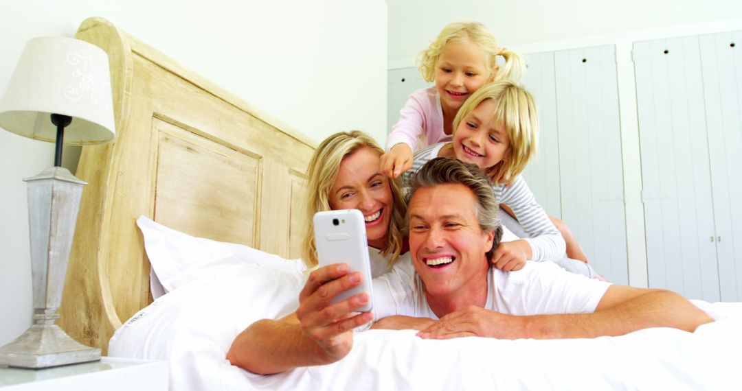 Joyful Family Taking Selfie in Bed, Creating Happy Moments Together - Free Images, Stock Photos and Pictures on Pikwizard.com