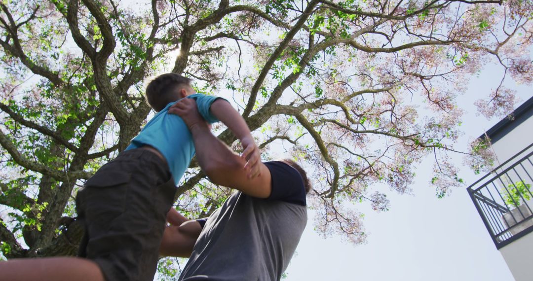 Father Lifting Son in Park on Sunny Day - Free Images, Stock Photos and Pictures on Pikwizard.com