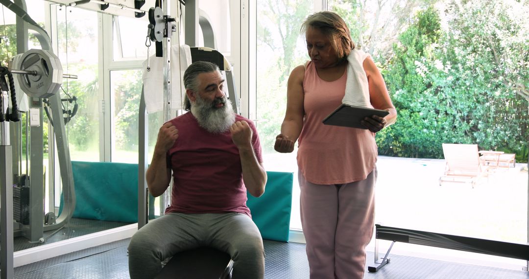 Senior Couple Exercising in Home Gym with Technology