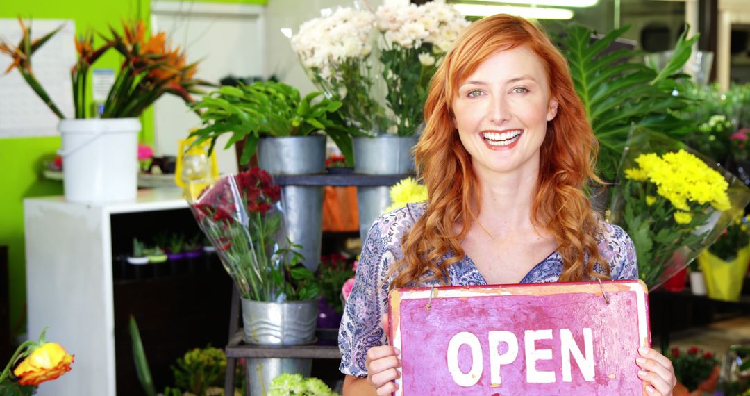 Smiling female florist holding open sign in vibrant flower shop - Free Images, Stock Photos and Pictures on Pikwizard.com