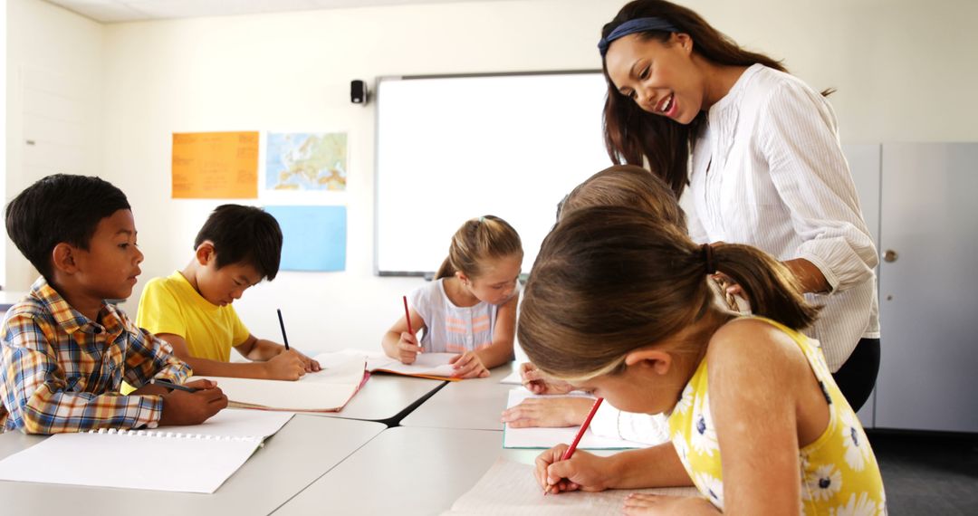 Smiling Teacher Guiding Engaged Students in Classroom Writing Activity - Free Images, Stock Photos and Pictures on Pikwizard.com