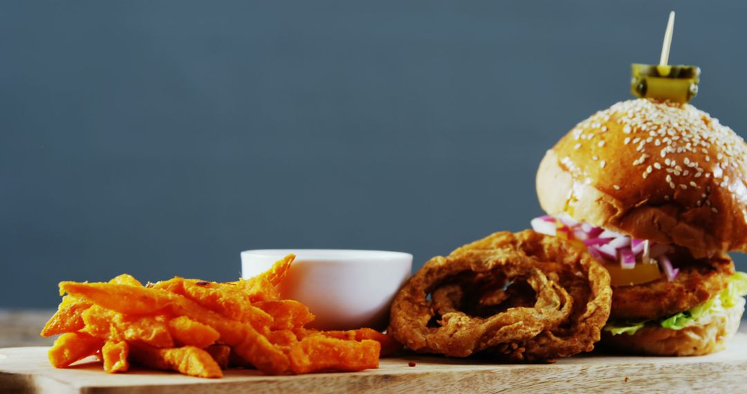 Close-up of Gourmet Burger with Sweet Potato Fries and Onion Rings - Free Images, Stock Photos and Pictures on Pikwizard.com