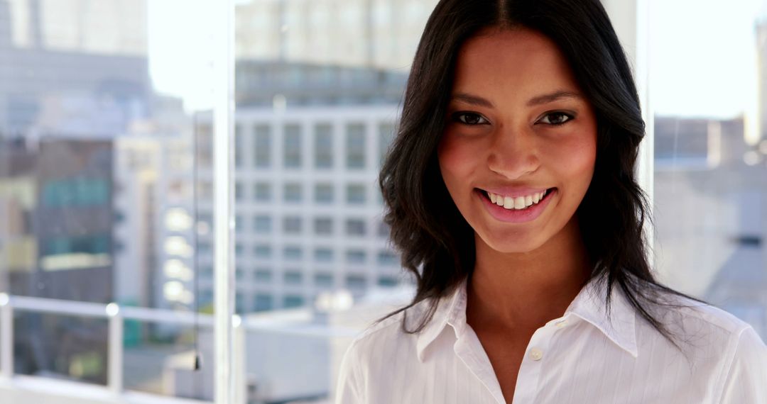 Smiling Businesswoman in Modern Office with City View - Free Images, Stock Photos and Pictures on Pikwizard.com