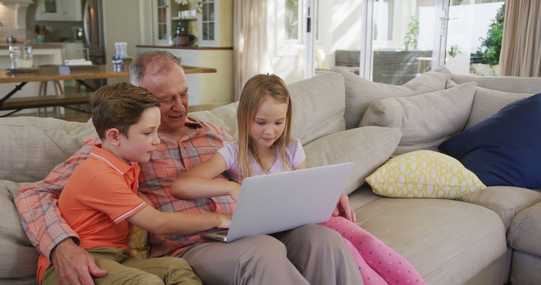 Grandfather and Grandchildren Using Laptop on Sofa - Free Images, Stock Photos and Pictures on Pikwizard.com