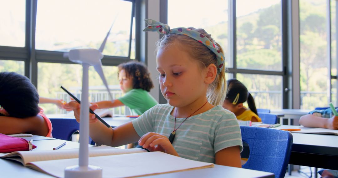 Schoolgirl Operating Modern Wind Turbine in Classroom