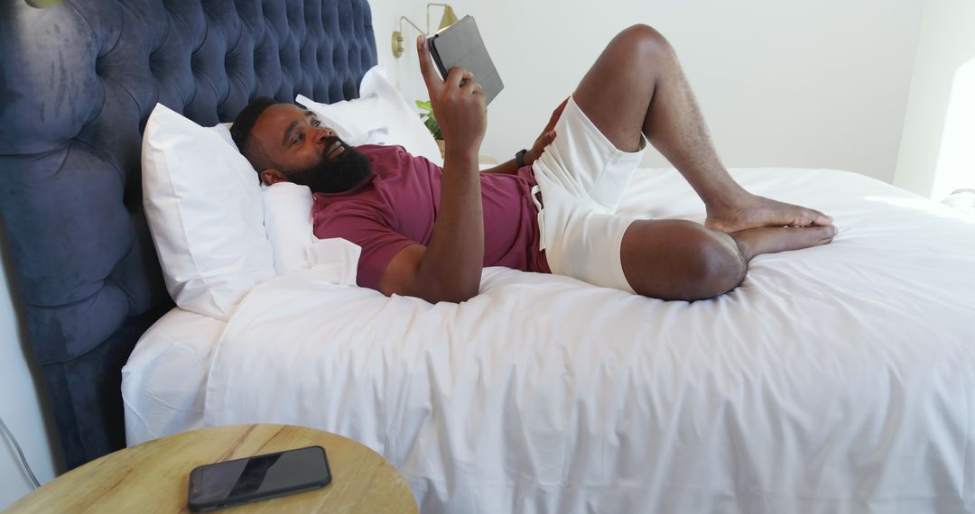 Man Relaxing with Tablet in Modern Bedroom