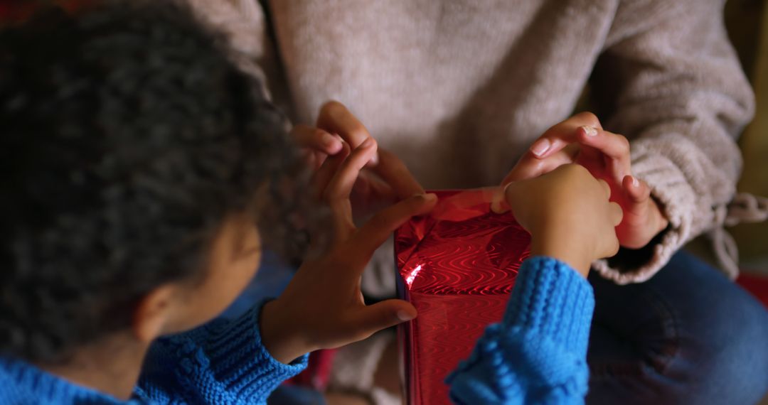 Children Wrapping a Gift with Red Shiny Paper - Free Images, Stock Photos and Pictures on Pikwizard.com