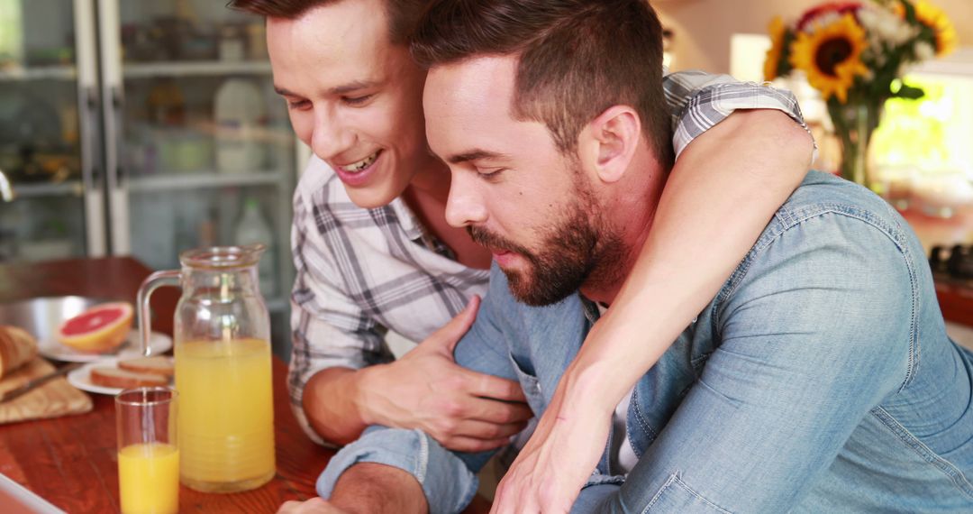 Happy Gay Couple Using Laptop in Home Kitchen - Free Images, Stock Photos and Pictures on Pikwizard.com