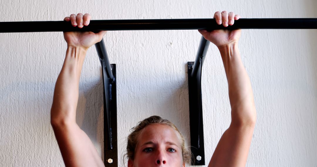 Young Woman Performing Pull-Ups on Home Workout Station - Free Images, Stock Photos and Pictures on Pikwizard.com