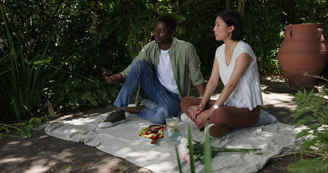 Interracial Couple Enjoying Picnic in Serene Garden Setting