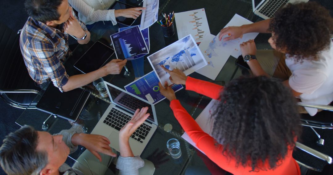 Team Collaborating on Business Graphs in Office Meeting