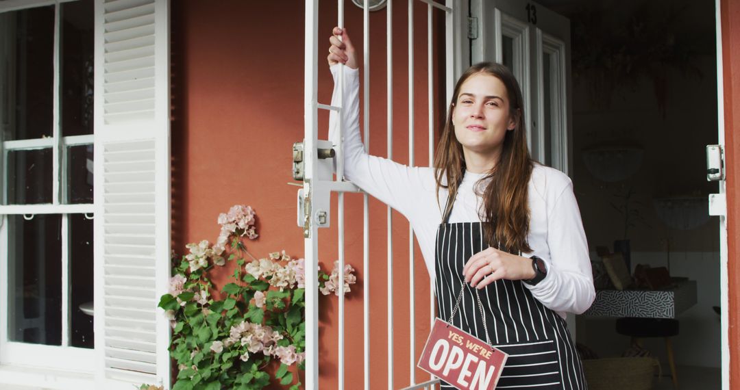 Friendly Waitress Holding Open Sign at Cafe Entrance