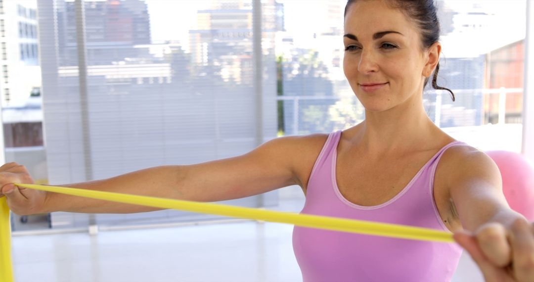 Woman exercising with resistance band in fitness studio - Free Images, Stock Photos and Pictures on Pikwizard.com