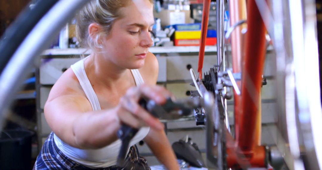 Woman Repairing Bicycle Chain in Workshop - Free Images, Stock Photos and Pictures on Pikwizard.com